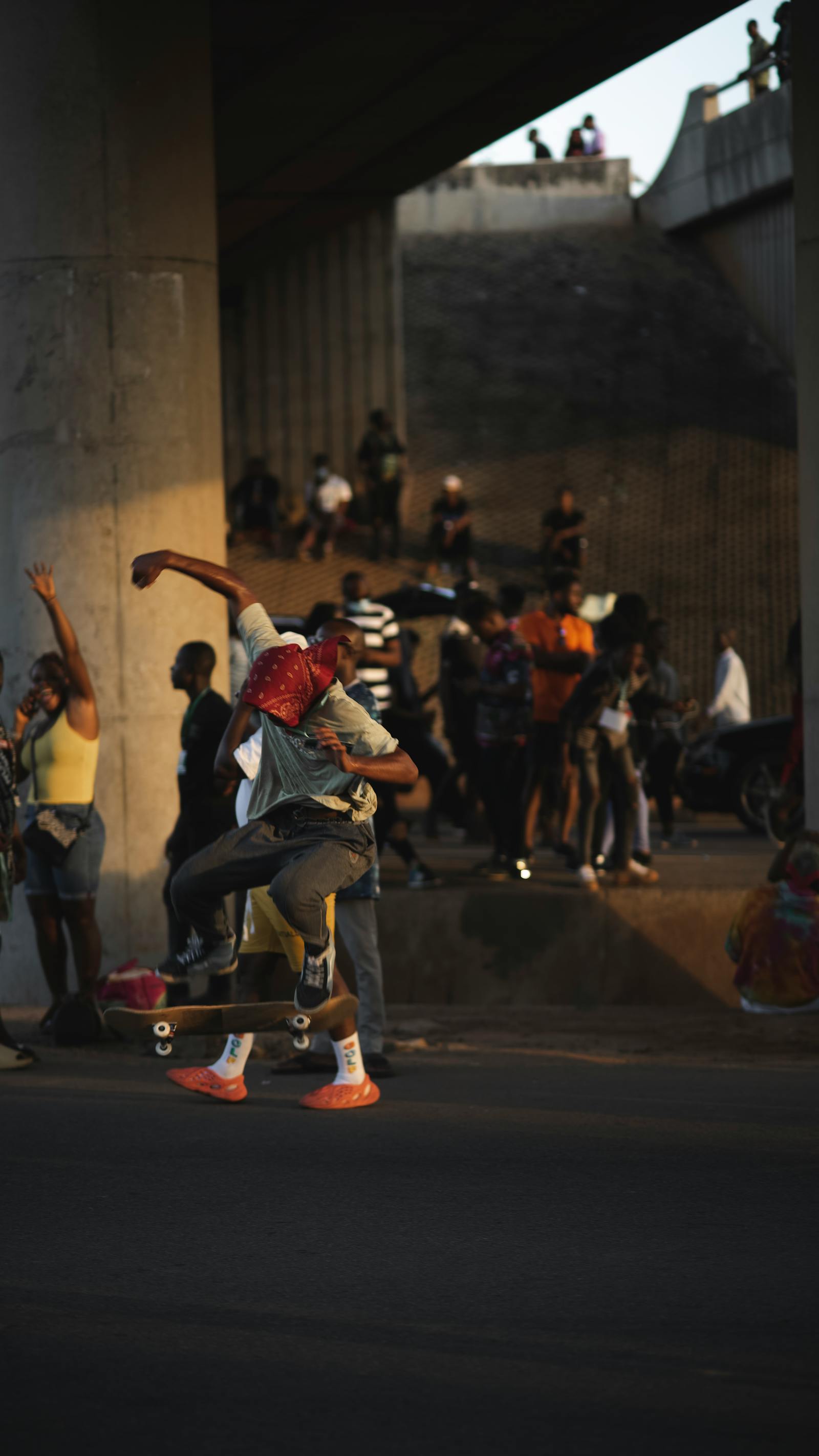 Skaters gathered under a concrete bridge